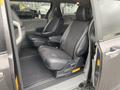 Interior view of a 2013 Toyota Sienna showing two leather front seats with armrests in a spacious minivan cabin