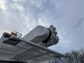 The image shows a white bucket truck's elevated arm and bucket mechanism positioned for aerial work