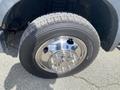 A close-up of a tire and chrome wheel of a 2010 Ford F-550 featuring a Michelin tire and shiny lug nut covers