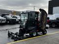 A 2020 Jacobsen HR800 turf maintenance machine with its cutting deck raised showing the mowing blades and controls inside the cab