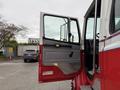 A red and white 2001 Freightliner FL80 with an open door showing a metallic step and interior dashboard details