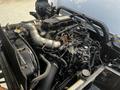 Engine compartment of a 2020 Hino 195 featuring multiple metal pipes hoses and a large engine block