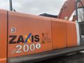 A 2006 Hitachi ZX200LC excavator with an orange exterior displaying the ZAXIS 200 logo and a company sticker on its side