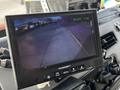 A monitor displaying a rearview camera feed showing a clear road ahead from a 1994 Freightliner FL80 truck