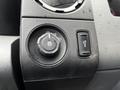 A close-up of the control panel in a 2011 Ford F-250 SD showing the headlight dial and a button with a light symbol