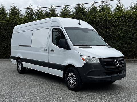 2019 Mercedes-Benz Sprinter van with a white exterior and black accents parked at an angle showing the front and side profile