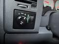 A control panel in a 2008 Dodge Ram 5500 featuring a knob for lights and various switches with an illuminated indicator