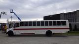 A 2013 Freightliner M2 106 school bus with a white body and red stripe parked on a concrete surface