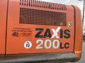 A close-up of a 2006 Hitachi ZX200LC excavator showcasing its orange exterior and identifying labels including the model name ZAXIS 200LC and company information