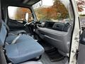 Interior view of a 2012 Mitsubishi Fuso FE with blue fabric seats and a gray dashboard showcasing controls and gauges