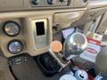 Interior view of a 2000 Ford F-350 SD showing the gear shift lever with a round token positioned on it and two round gauges to the left