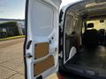 2022 Ford Transit Connect with an open side door revealing an empty cargo area and wall paneling