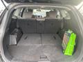 The interior of a 2017 Hyundai Santa Fe with the back seats folded down showing a spacious cargo area and a shopping bag in the corner