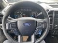 A 2017 Ford F-150 steering wheel with control buttons and the Ford logo in the center