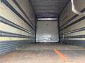 An empty interior of a 2008 Hino 268 truck with metal and wood flooring and vertical metal slats along the walls