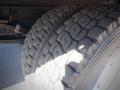 Close-up of two heavy-duty tires mounted on a 2013 Mitsubishi Fuso FE 160 showcasing their tread pattern and rubber composition