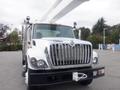 A silver 2009 International 7400 truck with a large front grille and an extended white aerial boom mounted on top