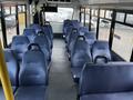 Interior of a 2017 Chevrolet Express featuring blue upholstered seating arranged in rows with a clear aisle in the center