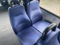 Two blue fabric seats with armrests designed for passenger use in a Chevrolet Express van