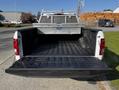The image shows the open bed of a white 2017 Ford F-150 with a black liner and a metal tool box installed in the center of the truck bed