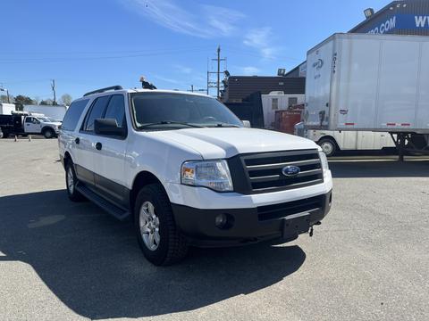 A white 2013 Ford Expedition with a black lower body and front grille parked on a paved surface