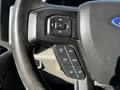 Close-up of the steering wheel controls of a 2017 Ford F-150 featuring buttons for navigation and cruise control