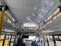 Interior view of a 2017 Chevrolet Express showing overhead lights and grab bars with rows of blue seats visible