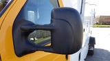 Close-up of the side mirror of a 2015 Ford Econoline with a black housing and a reflective surface