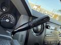 Close-up of the steering column in a 2016 Ford F-350 SD showing the gear shift lever with buttons for towing and a speedometer in the background