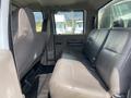 Interior view of a 2010 Ford F-550 showing the rear bench seat with grey upholstery and seat belts