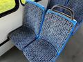 Two blue upholstered bus seats with a floral pattern, positioned side by side, showing their sturdy metal frames