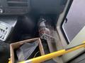 A 2012 Chevrolet Express interior view showing a fire extinguisher positioned near the front passenger area and a box containing miscellaneous items on the floor