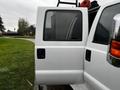 A 2014 Ford F-550 with an open door showcasing the white exterior and side view of the vehicle