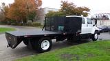 A 2008 Chevrolet C7500 flatbed truck with a black flatbed and a side-mounted tool compartment