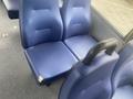 Two blue vinyl seats from a 2017 Chevrolet Express with a small tear on one seat