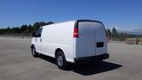 A white 2012 GMC Savana cargo van is parked with its rear and side visible showing a smooth exterior and chrome wheels