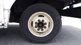 A close-up view of a wheel on a 2011 Ford Econoline showing the white metal rim and a black tire with visible tread patterns