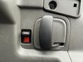 Close-up of a door handle and window switch on a 2009 Chevrolet Express interior panel