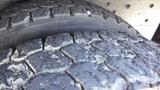 Close-up of a worn tire showing deep cracks and significant tread wear on a 2014 International 3000