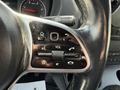 Close-up of the steering wheel controls of a 2019 Mercedes-Benz Sprinter featuring buttons for volume phone and settings
