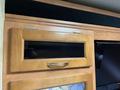 Interior detail of a 2008 Newmar Canyon Star 36 Foot Class A Motorhome featuring a wooden cabinet with a glass window and a metal handle