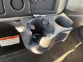 A cup holder with a small item inside located in the cab of a 2013 International 4300 truck