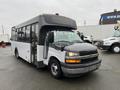 A 2018 Chevrolet Express bus with a white body and black accents has large windows and a prominent front grille