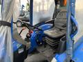 A blue 2007 New Holland TN70A tractor with a driver's seat steering wheel and control levers visible in the operator's cab