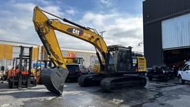 A 2018 Cat 326F Track excavator with a large front bucket and tracks visible in the foreground