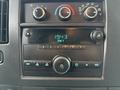 A dashboard panel of a 2009 Chevrolet Express featuring climate controls a radio display and audio control buttons