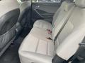 The interior of a 2017 Hyundai Santa Fe showing the backseat with gray upholstery and seat belts