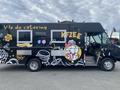 2011 Ford Utilimaster Food Truck with a black exterior featuring colorful graphics and text promoting catering services and delicious food options