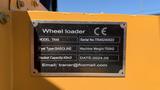 A metal identification plate attached to a wheel loader displaying model information serial number fuel type machine weight bucket capacity and date