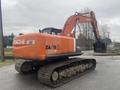 2006 Hitachi ZX200LC excavator with an orange body and black tracks positioned for digging